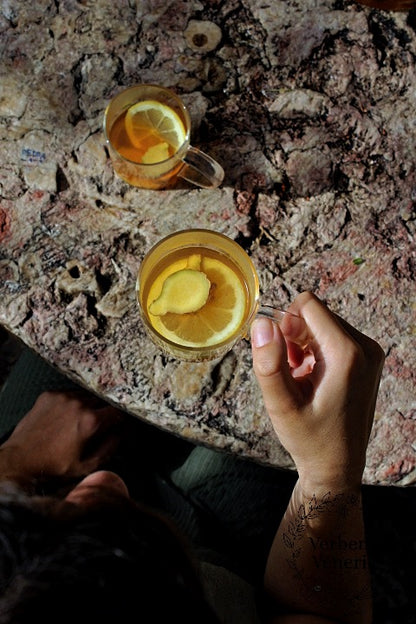 Context picture - a women holding a cup of the infusion Exotic Feeling with a slice of lemon and ginger