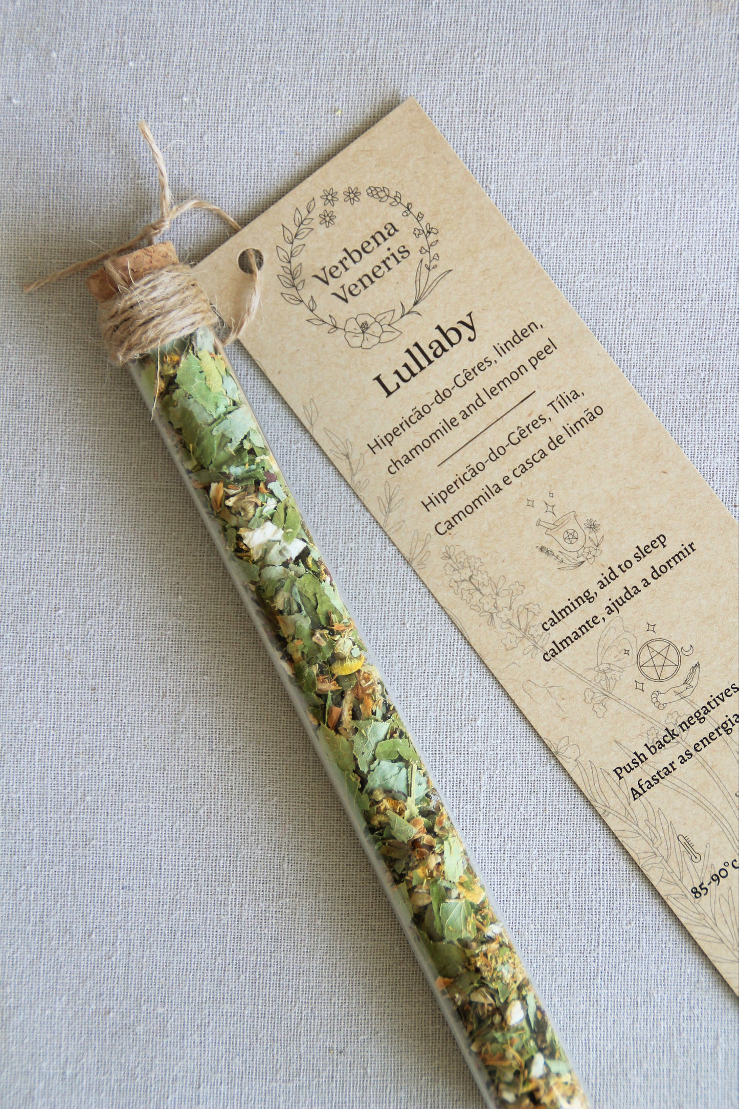 chemist glass tube closed with a cork top tighten with some  ropes. It contains the herbal blend called Lullaby. A kraft label tag is attached to it, with all the information regarding the herbs.
