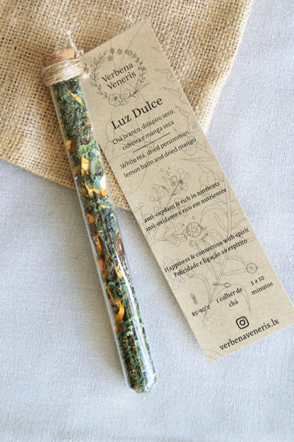 chemist glass tube closed with a cork top tighten with some  ropes. It contains the herbal blend called Luz Dulce. A kraft label tag is attached to it, with all the information regarding the herbs.