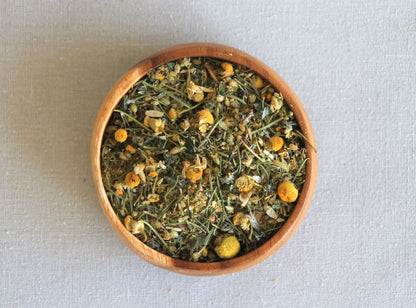 Herbal blend Moon cycle in a wooden bowl, allows us to see all the ingredients; camomile, rosemary, raspberry leaf, yarrow, oregano and fennel seeds