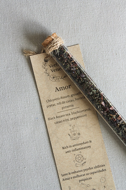 chemist glass tube closed with a cork top tighten with some  ropes. It contains the herbal blend called Amor. A kraft label tag is attached to it, with all the information regarding the herbs.