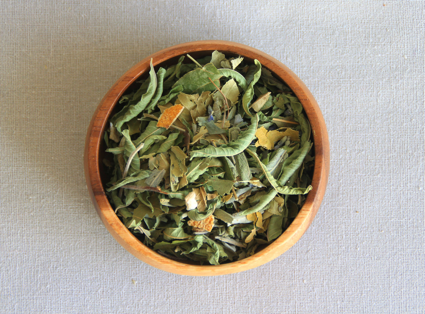 Herbal blend Take it easy in a wooden bowl, allows us to see all the ingredients; lemon verbena, orange leaf, orange peel, sage, bay leaf, lavender, 