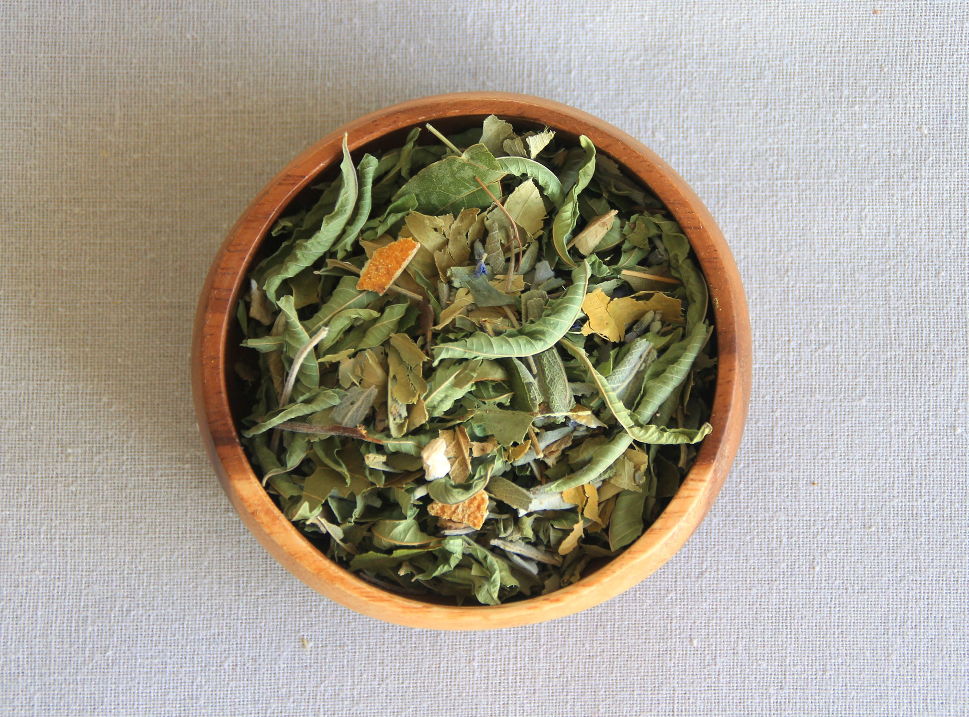 Herbal blend Take it easy in a wooden bowl, allows us to see all the ingredients; lemon verbena, orange leaf, orange peel, sage, bay leaf, lavender, 